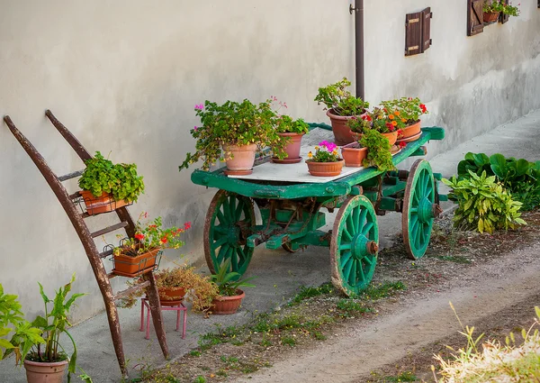 Květináče s květinami na dřevěný vozík v Itálii. — Stock fotografie