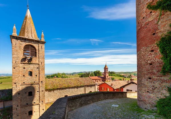 Glockenturm und mittelalterliche Ziegelmauer in einer kleinen italienischen Stadt. — Stockfoto