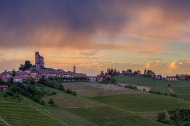 Small town on the hill under cloudy sky in Italy. clipart