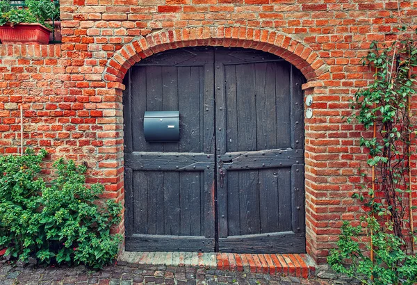Drewniane drzwi i ściany z czerwonej cegły. — Zdjęcie stockowe