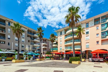 Alba, Piedmont, Kuzey İtalya 'da mavi gökyüzü altında inşaat vinçleri ve yeni konut binaları.