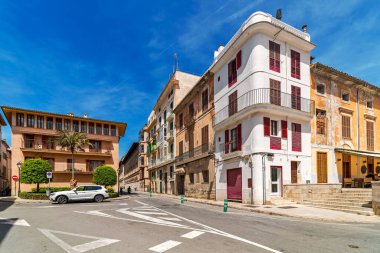 İspanya, Palma de Mallorca 'da mavi gökyüzünün altında şehir caddesi ve eski renkli evler.
