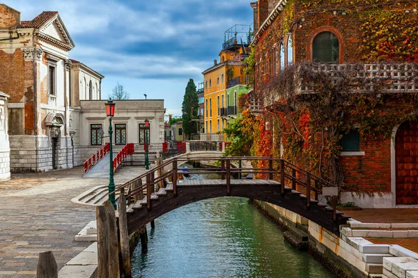 狭い運河とヴェネツィア イタリアの典型的なカラフルな家の上の小さな木製の橋 — ストック写真