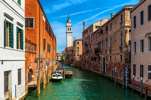 イタリアのヴェネツィアを背景に鐘楼として古い家の間の狭い運河上のボートの眺め — ストック写真