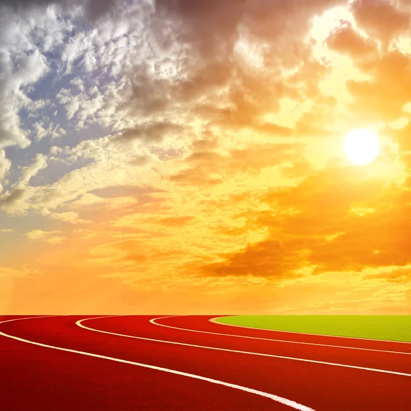 Atletismo pista carril con hermoso cielo aver la puesta de sol — Foto de Stock