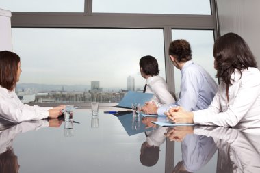 Four businesspeople looking out of the window clipart