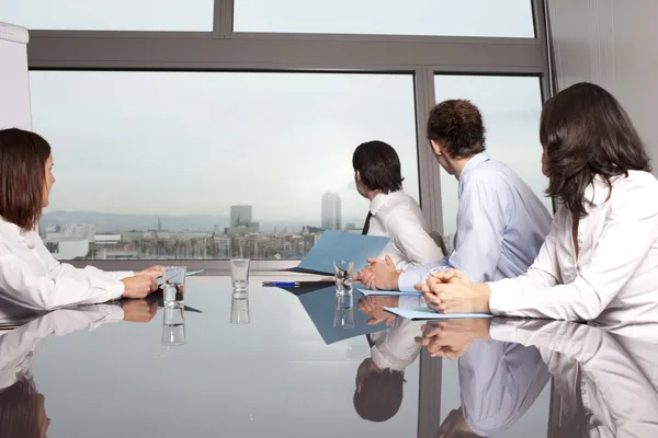 Four businesspeople looking out of the window — Stock Photo, Image