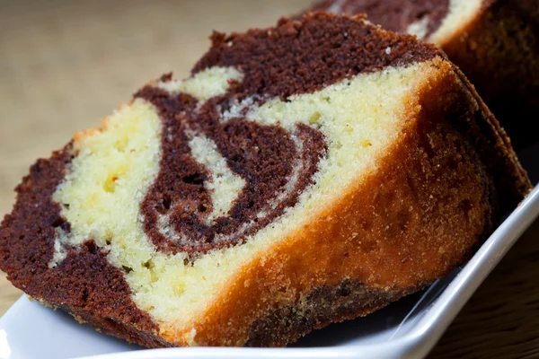 Beyaz bir tabak kahverengi artalanları ile ev yapımı mermer kek dilimleri - Stok İmaj