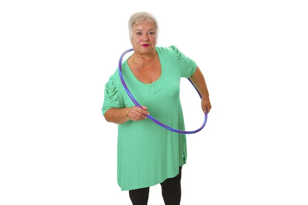 Starší dáma dělá gymnastiku s hula-hoop — Stock fotografie