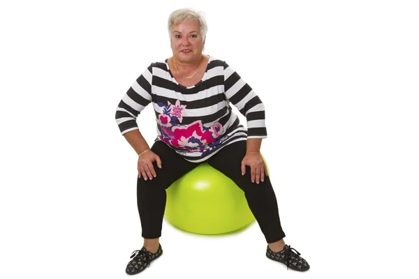 Femme âgée assise sur une balle suisse — Photo