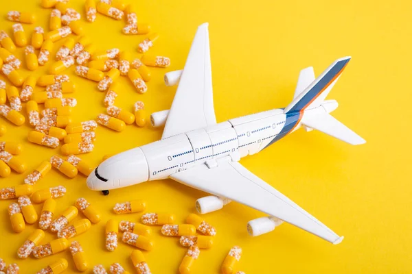 Conceito Doença Viagem Avião Brinquedo Com Pílulas Amarelas Fundo Amarelo — Fotografia de Stock