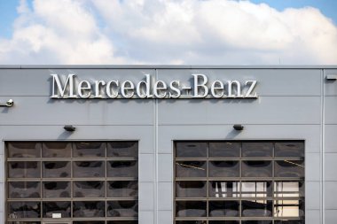 GIESSEN, GERMANY - 2021 _ 04 _ 09: Modern bir araba satıcısı binasında asılı Mercedes-Benz logosu. Mercedes-Benz, Alman DAX şirketi Daimler 'in küresel otomobil markası..