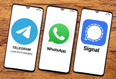 HUETTENBERG, GERMANY 2021-12 _ 14: Cep telefonu ekranında TELEGRAM WhatSAPP ve SIGNAL App. Ahşap arkaplanda üst görünüm.