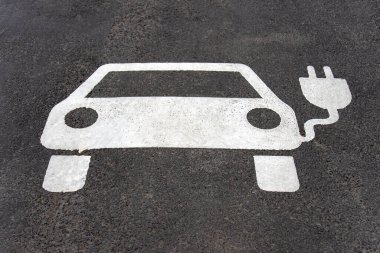 Elektrikli araba için ayrılmış park yeri. Asfalt araba ve fişle işaretlenmiş..