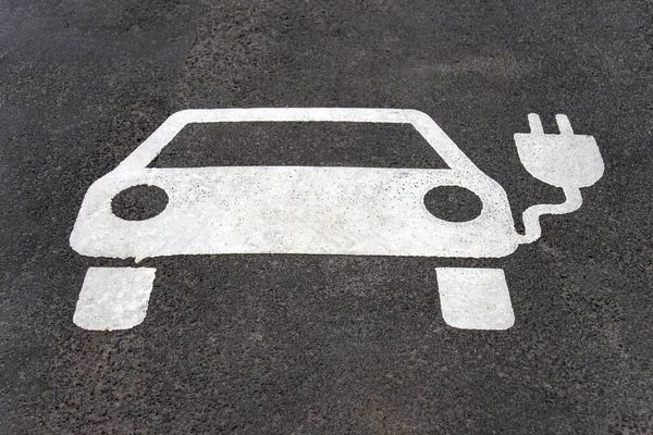 Elektrikli araba için ayrılmış park yeri. Asfalt araba ve fişle işaretlenmiş..