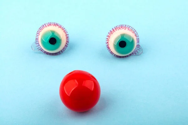 Ojos Caramelo Fruta Decorativos Con Nariz Roja Sobre Fondo Azul — Foto de Stock