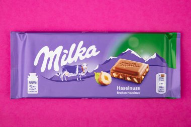 WETZLAR; ALMANY - 2022-04-11: Mor arka planda Milka çikolatası. Sütlü çikolata. Milka, 1901 yılında İsviçre 'de üretilen bir çikolata markasıdır..
