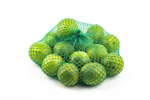 Fresh limes in the net green lime citrus fruit stand isolated on white background. Lime wedge with clipping path