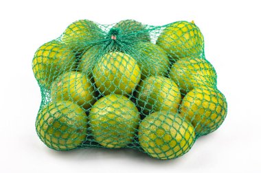 Fresh limes in the net green lime citrus fruit stand isolated on white background. Lime wedge with clipping path