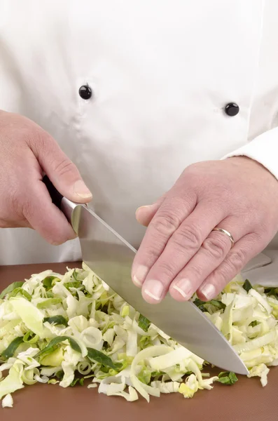 Female chef cuts cabbage with a large knife — Stock Photo, Image