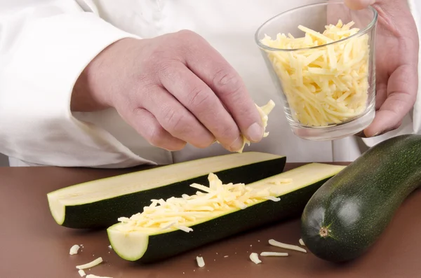 Female chef and zucchini with grated cheese — Stock Photo, Image