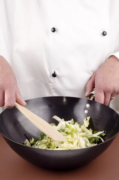 Female chef and cabbage in a wok — Stock Photo, Image