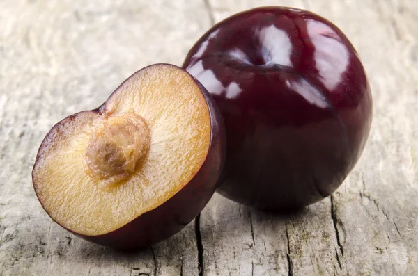 Organic plum on a wooden background — Stock Photo, Image
