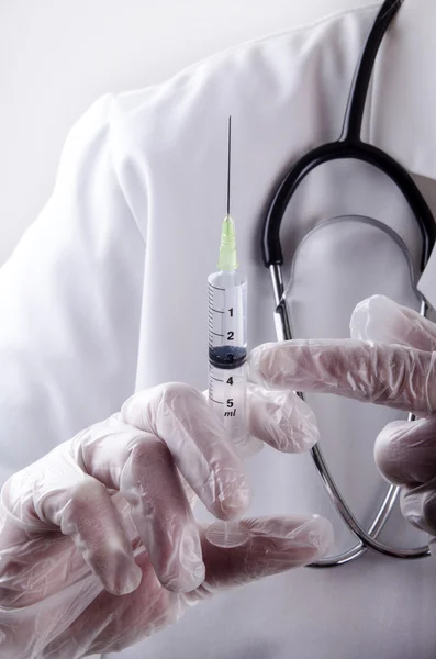 Pessoal médico segurando uma seringa — Fotografia de Stock