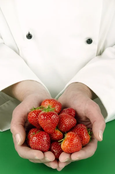 Chef femelle tenant quelques fraises — Photo