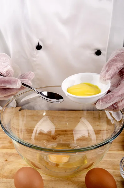 Female chef holds a small bowl with mustard — Stock Photo, Image