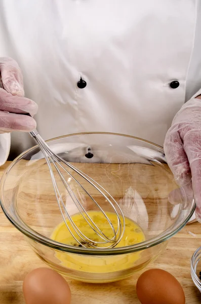 Шеф-повар смешивает яйцо, масло и уксус — стоковое фото