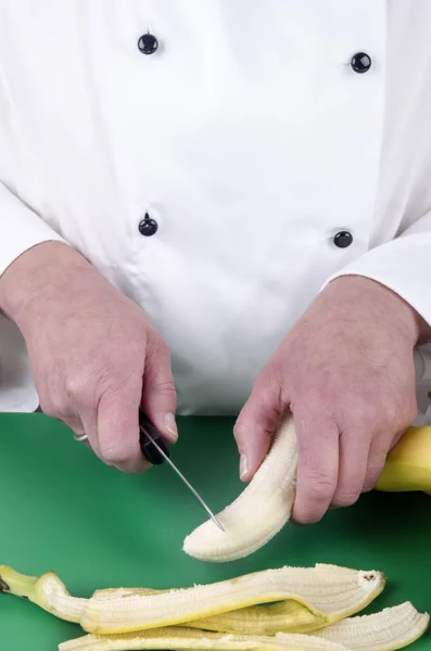 Vrouwelijke chef-kok voorbereiding van een banaan — Stockfoto