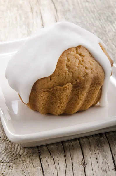 Bolinho em uma chapa colorida de creme — Fotografia de Stock