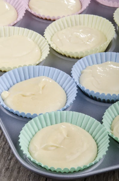 Vanilla cake batter in a cupcake baking tin — Stock Photo, Image