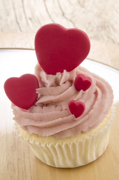 Cupcake with pink butter cream and hearts — Stock Photo, Image