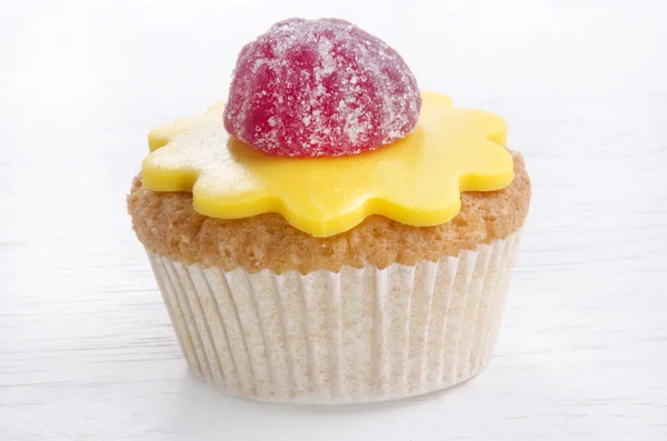 Cupcake with yellow icing and wine gum fruit — Stock Photo, Image