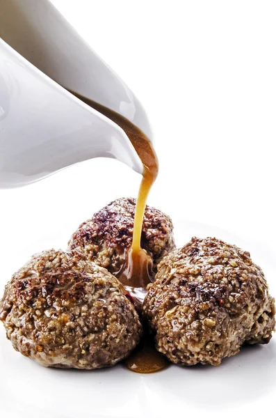 Sauce flows on three peppered meatballs — Stock Photo, Image