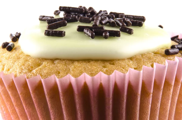 Cupcake com cobertura verde e polvilhas de chocolate — Fotografia de Stock