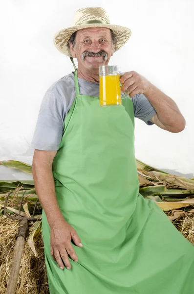 Organic farmer is holding a glass orange juice — Stock Photo, Image