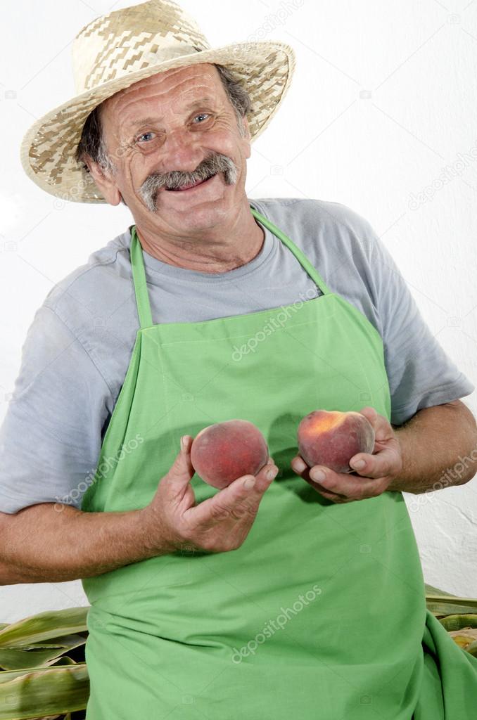 Organic farmer with two peaches in his hand