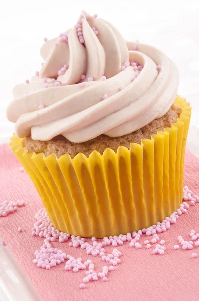 Pembe peçete üzerinde pembe sprinkles ile cupcake — Stok fotoğraf