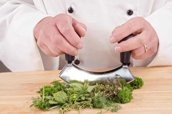 Herbs are chopped with a herb cutter — Stock Photo, Image