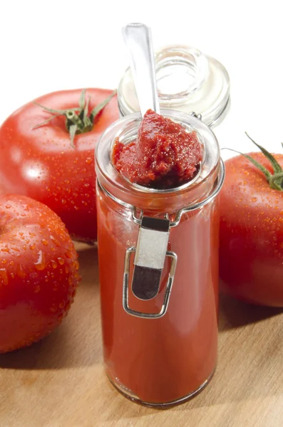 Tomatoes and tomato paste in a glass — Stock Photo, Image