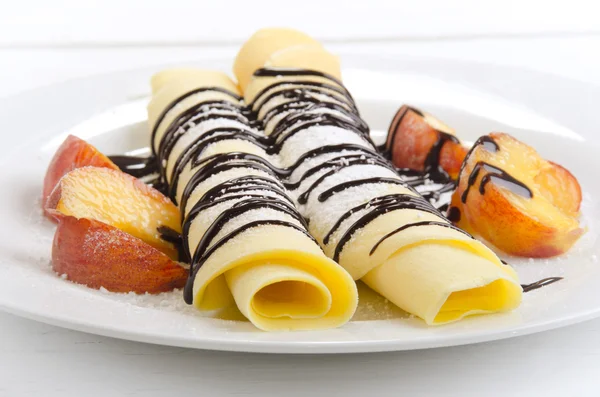 Pancake with chocolate sauce and peach — Stock Photo, Image