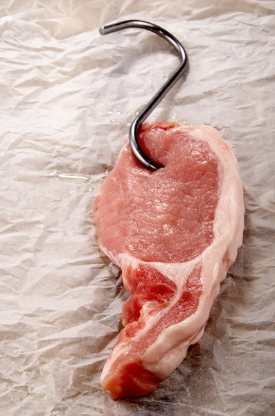Bistecca di lonza di maiale a un gancio di macellaio — Foto Stock