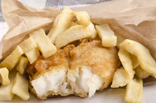 Peixe e batatas fritas em um saco marrom — Fotografia de Stock