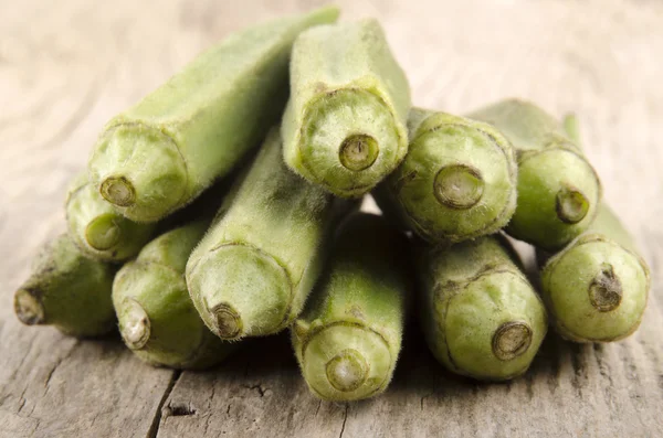 Okra crudo su uno sfondo di legno — Foto Stock