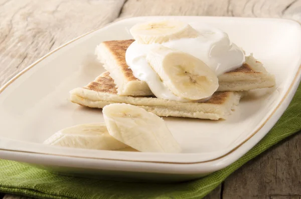 Potato pancakes with sour cream and banana — Stock Photo, Image