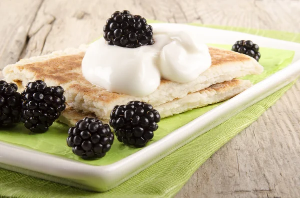 Potato pancakes with sour cream and blackberries — Stock Photo, Image