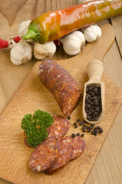 Sliced hungarian kolbasz on a wooden board — Stock Photo, Image